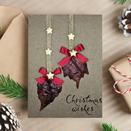 Handmade-Christmas-card-made-of two-dried-leaves-bow-and-stars