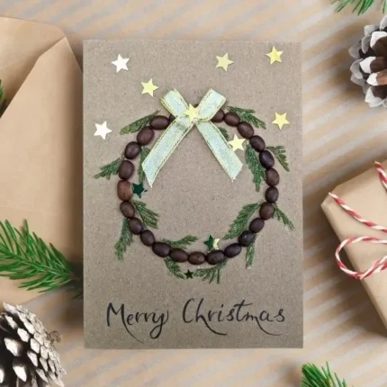 Handmade-Christmas-wreath-card-idea-with-wreath-made-of-coffee-beans-green-foliage-and-whi