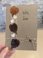 Handmade-Valentines-Day-Card-with-Dried-Leaves-and-Paper-Hearts-hold-in-hand