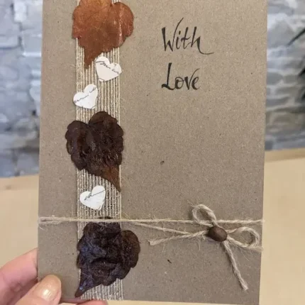 Handmade-Valentines-Day-Card-with-Dried-Leaves-and-Paper-Hearts-hold-in-hand