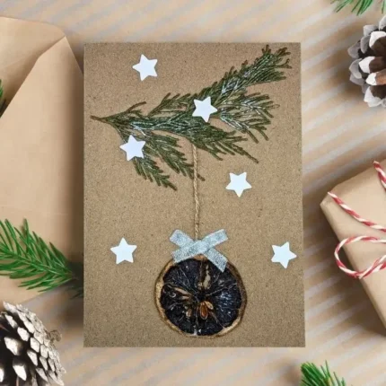 Handmade-Christmas-card-features-one-dried-orange-slice-a-branch-and-stars